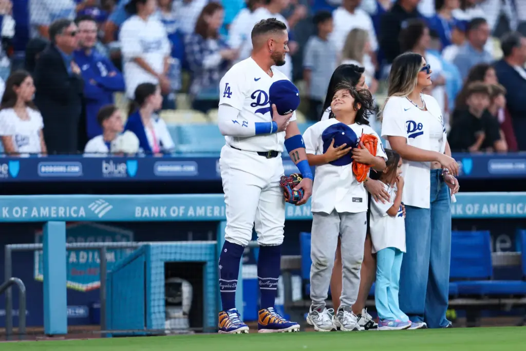 Dodgers infielder Miguel Rojas, left, interacts with his son, Aaron...