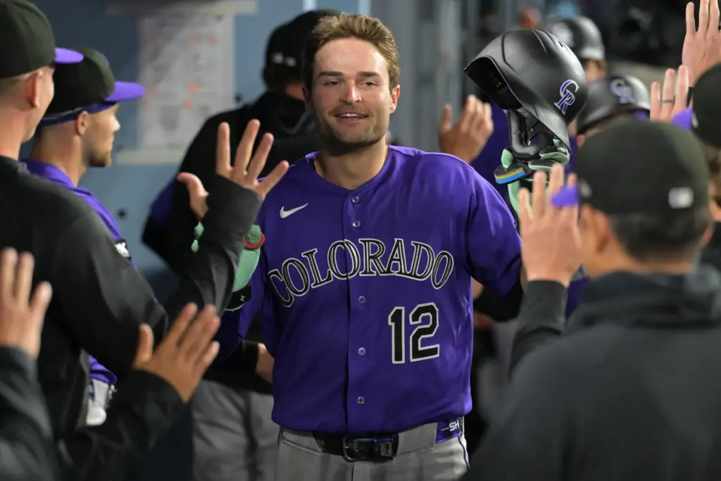 The Colorado Rockies’ Kyle Karros is greeted in the dugout...