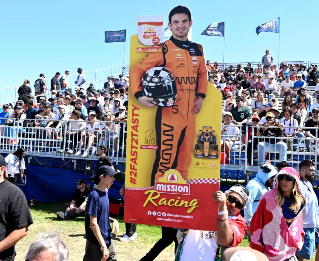 A race fan carries a cardboard cutout of his favorite...