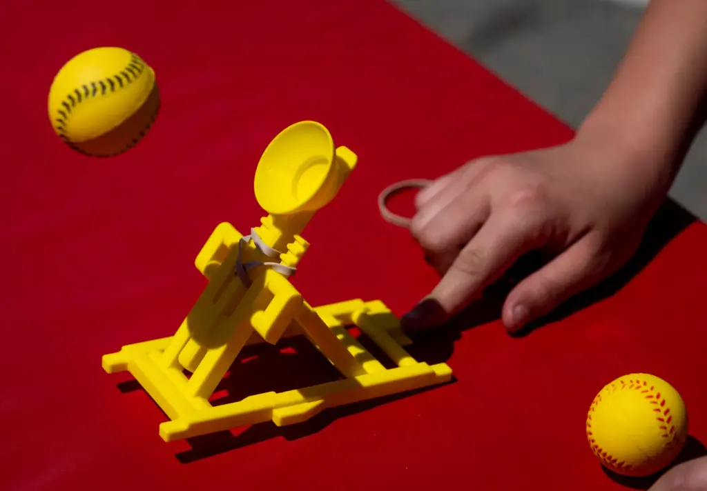 Students use a catapult to test launch angle during STEAM...