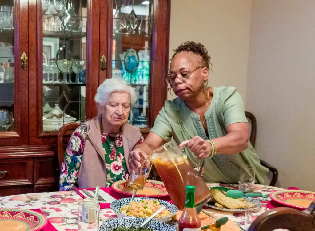 Darlene Hastings, right, pours tea for her elderly housemate, Ester...