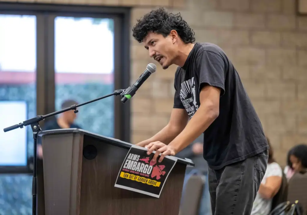 Remo Abboud of Mission Viejo holds a sign that reads...