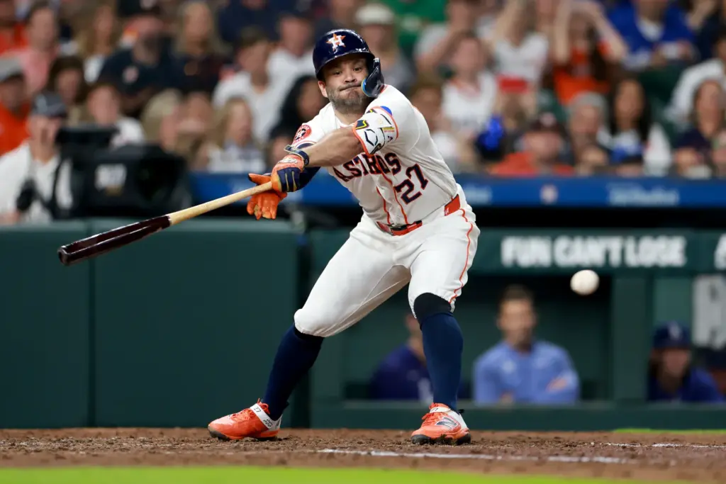 The Houston Astros’ Jose Altuve flails at a pitch as...