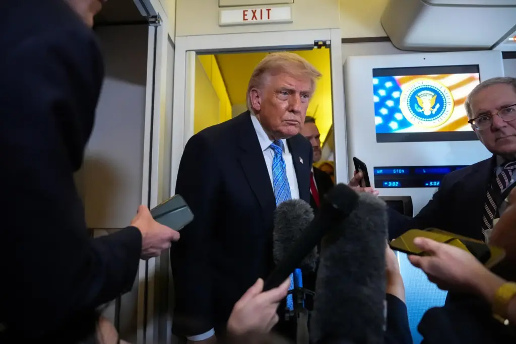 Donald Trump speaks to reporters aboard Air Force One