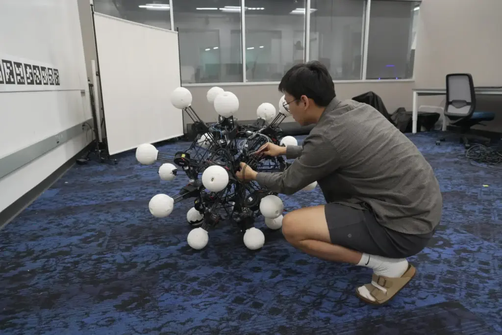 Jiaxun Liu, a Ph.D. student, works on a robot named...
