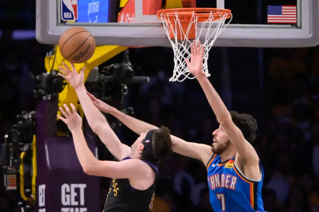 Lakers guard Austin Reaves, left, makes a layup off the...