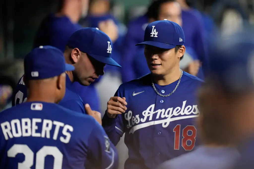 Dodgers starting pitcher Yoshinobu Yamamoto, right, greets Manager Dave Roberts...