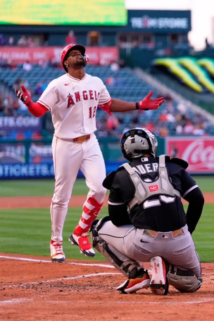 The Angels’ Jorge Soler, left, gestures as he finishes running...