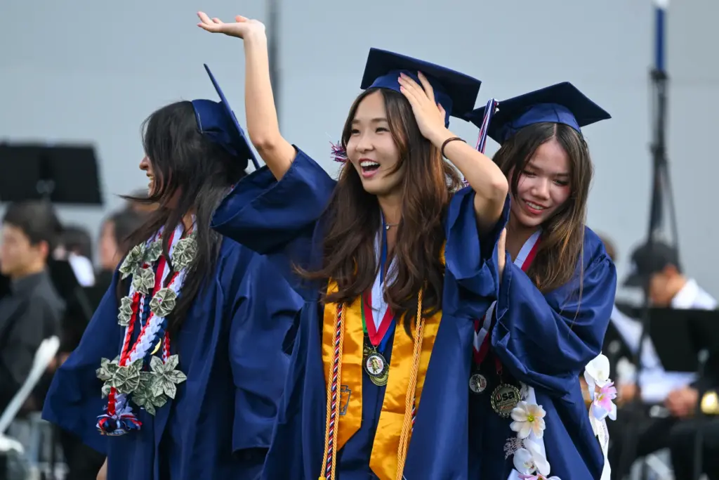 Jasline Kim waves to the crowd during the commencement ceremony...