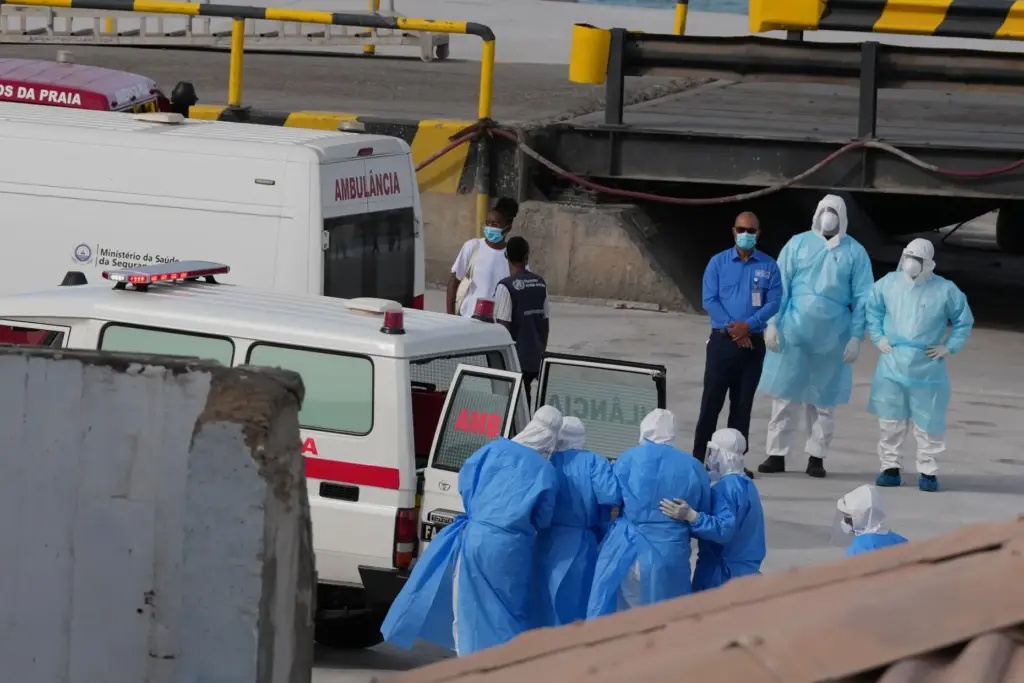 Health workers in protective gear evacuate patients