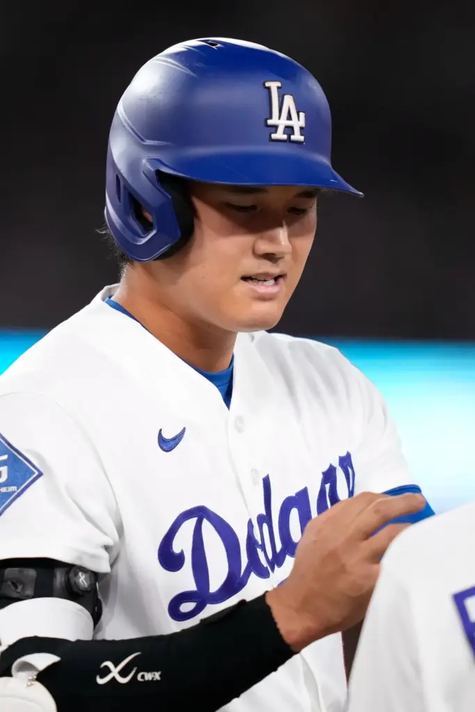 Dodgers star Shohei Ohtani looks at his right hand after...