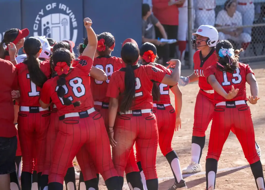 Whittier Christian players celebrate a home run by Mia Camacho...
