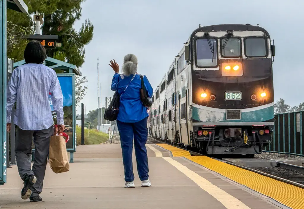 People greet an arriving northbound Metrolink train in Irvine, CA,...