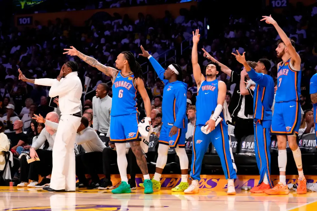 Members of the Oklahoma City Thunder cheer from the bench...