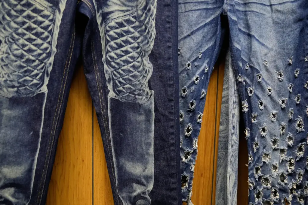 Patterns and distressing, made by a laser, are displayed at...