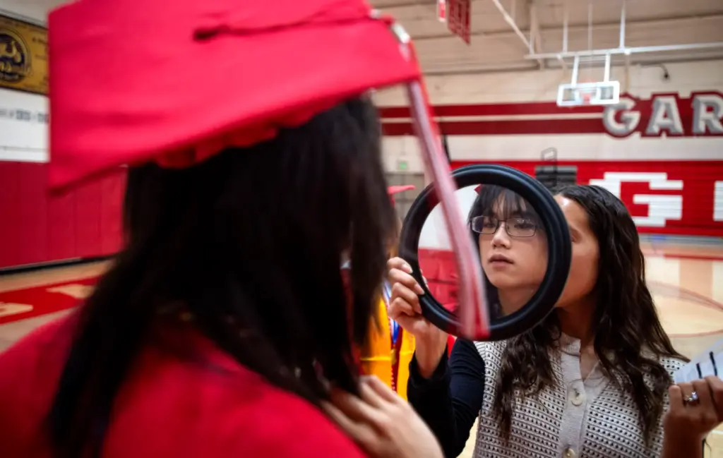 Julie OâBlenes holds a mirror so graduates could do some...