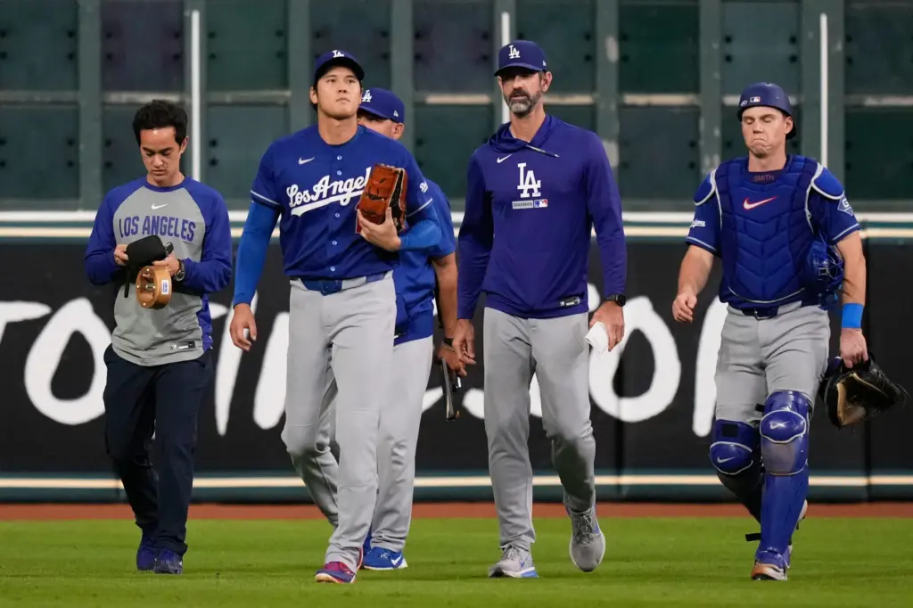 Dodgers starting pitcher Shohei Ohtani, second from left, walks to...