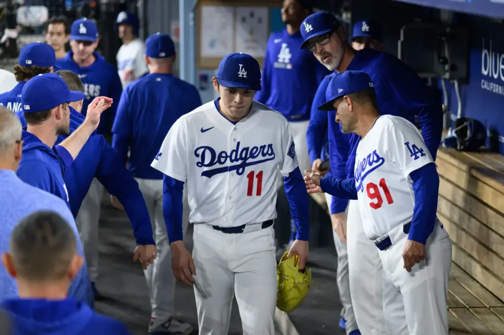 Dodgers starting pitcher Roki Sasaki (11) is greeted by coaches...