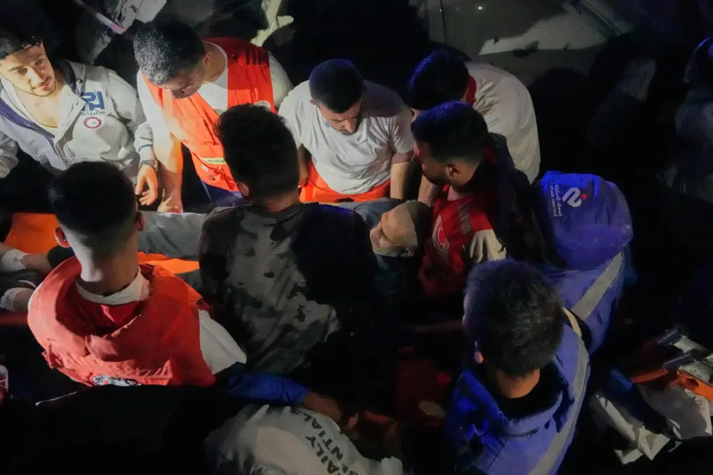 Rescue workers carry an injured man from a destroyed apartment.
