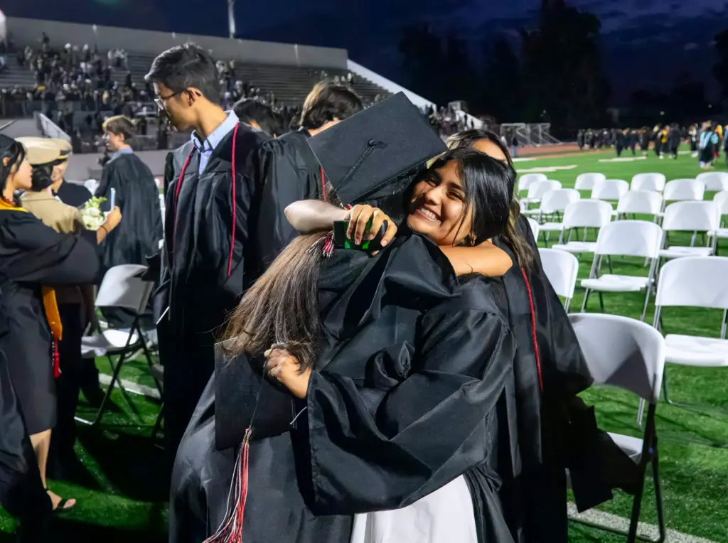 Graduate Nicole CabaÃ±as-Mejia hugs another graduate to celebrate following the...
