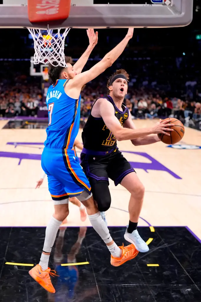 Lakers guard Austin Reaves, right, shoots as Oklahoma City Thunder...
