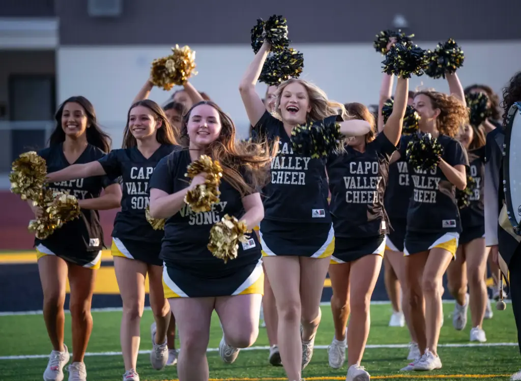 Capistrano Valley High School cheerleaders run onto the field in...