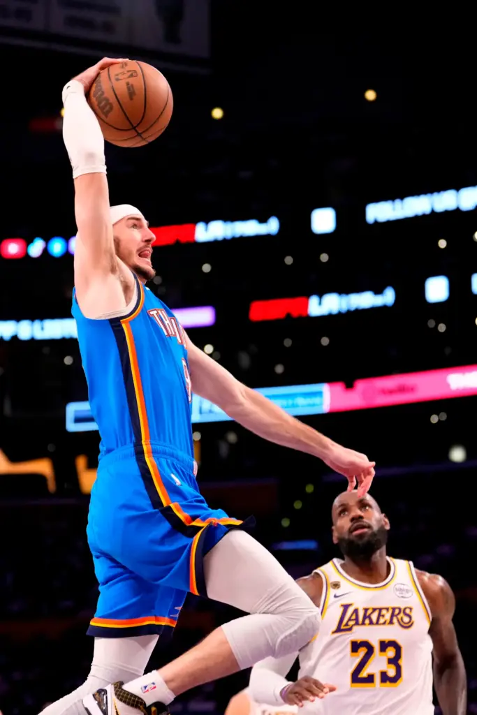 Oklahoma City Thunder guard Alex Caruso, left, soars to the...