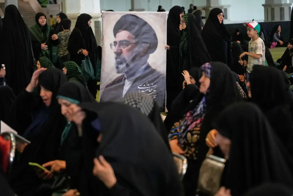 Women gather around a portrait of Iran’s Supreme Leader, Ayatollah...