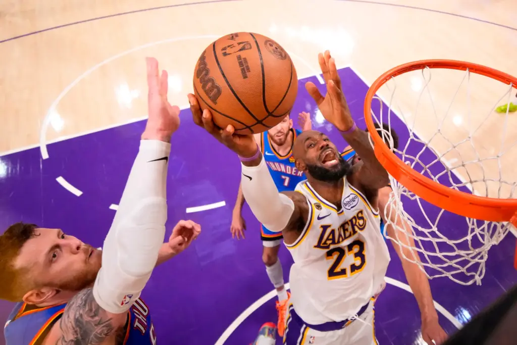 Lakers star LeBron James, right, shoots as Oklahoma City Thunder...