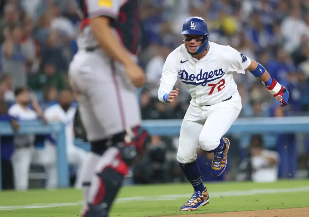 The Dodgers’ Miguel Rojas runs home to score the go-ahead...