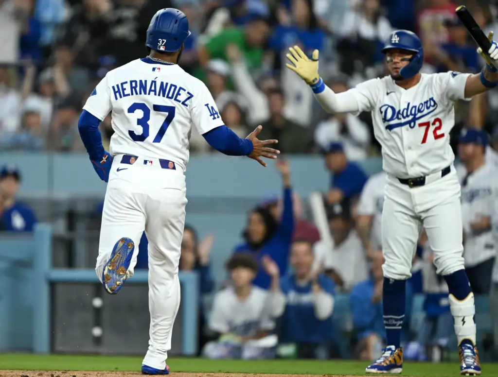 The Dodgers’ Teoscar Hernandez, left, is greeted by teammate Miguel...