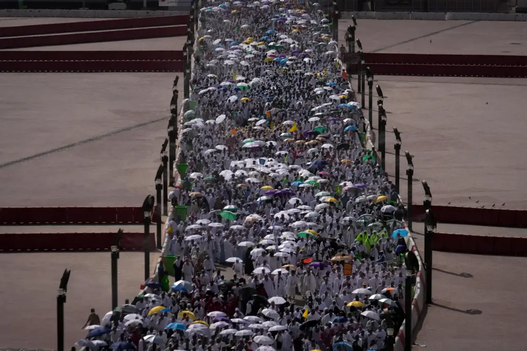 Muslim pilgrims walk on their way to cast pebbles at...