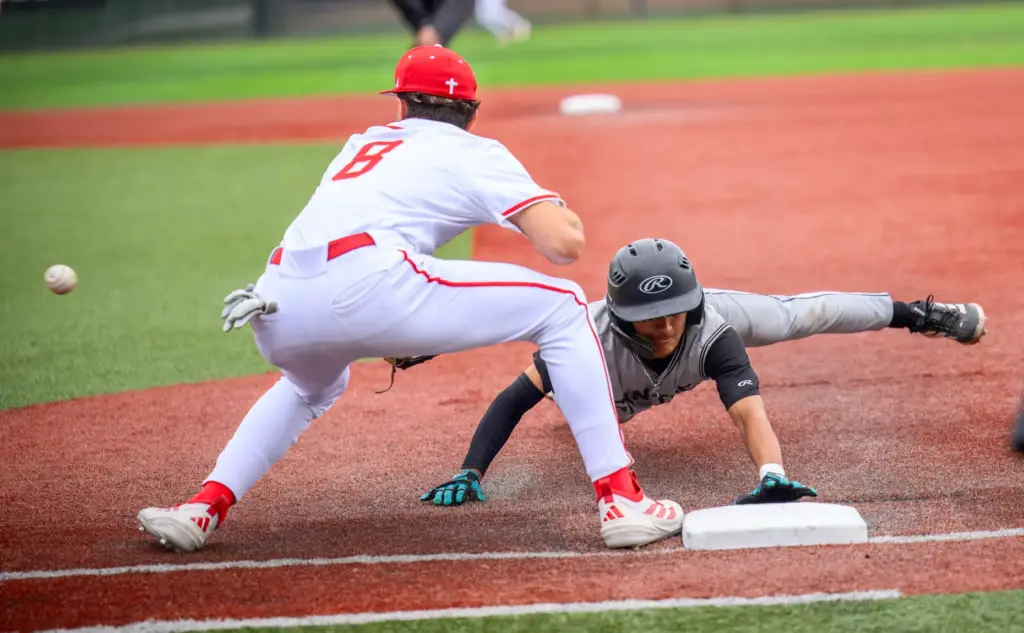 Santiago’s Ben Rausch dives back to the bag safely on...