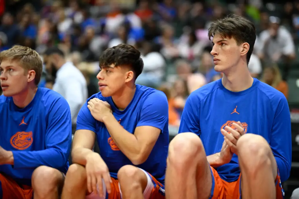 Florida center Olivier Rioux, right, watches from the end of...