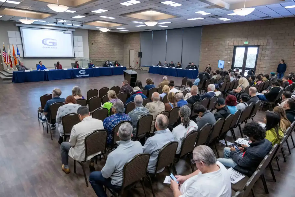 Members of the public listen to an update from city...