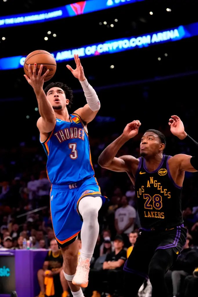 Oklahoma City Thunder guard Jared McCain, left, shoots as Lakers...