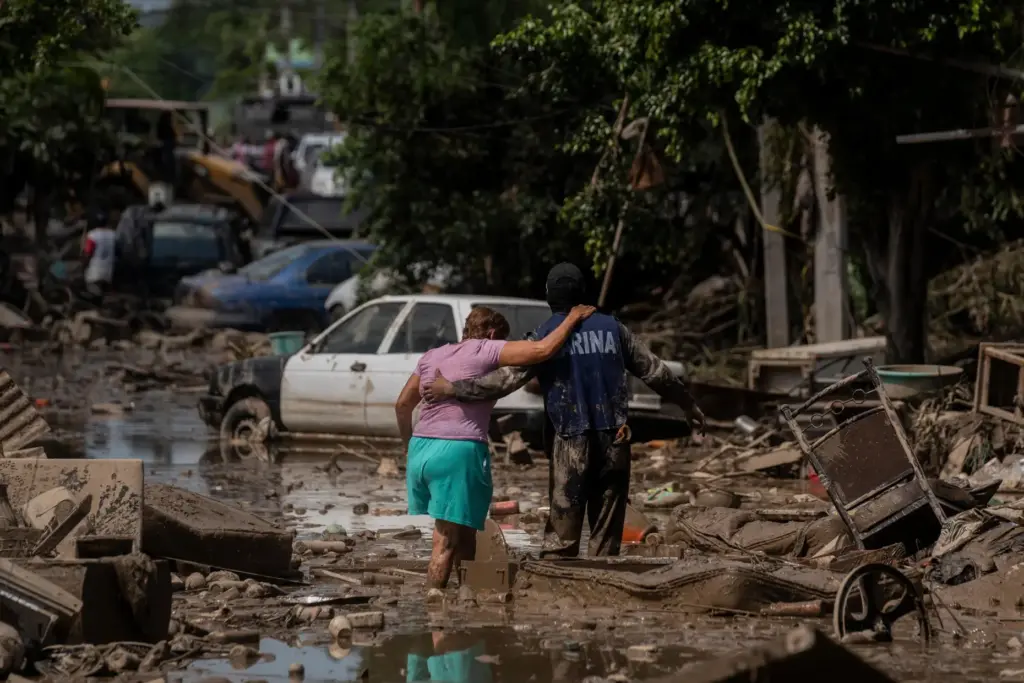 FILE – A Navy officer helps a woman cross a...