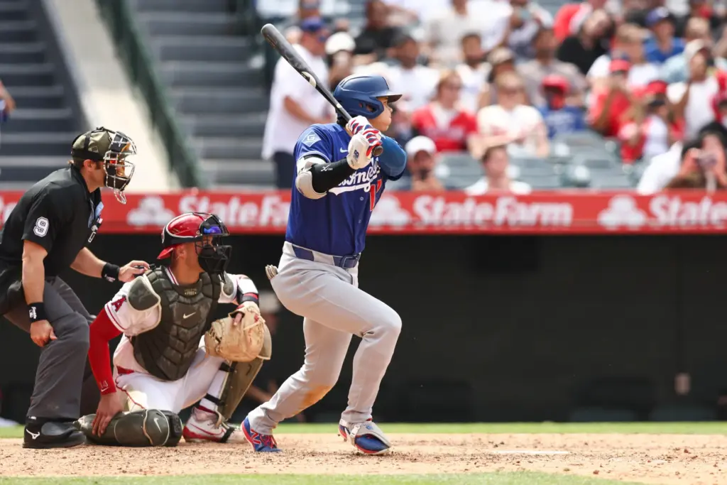 Dodgers’ Shohei Ohtani follows through on a single during the...