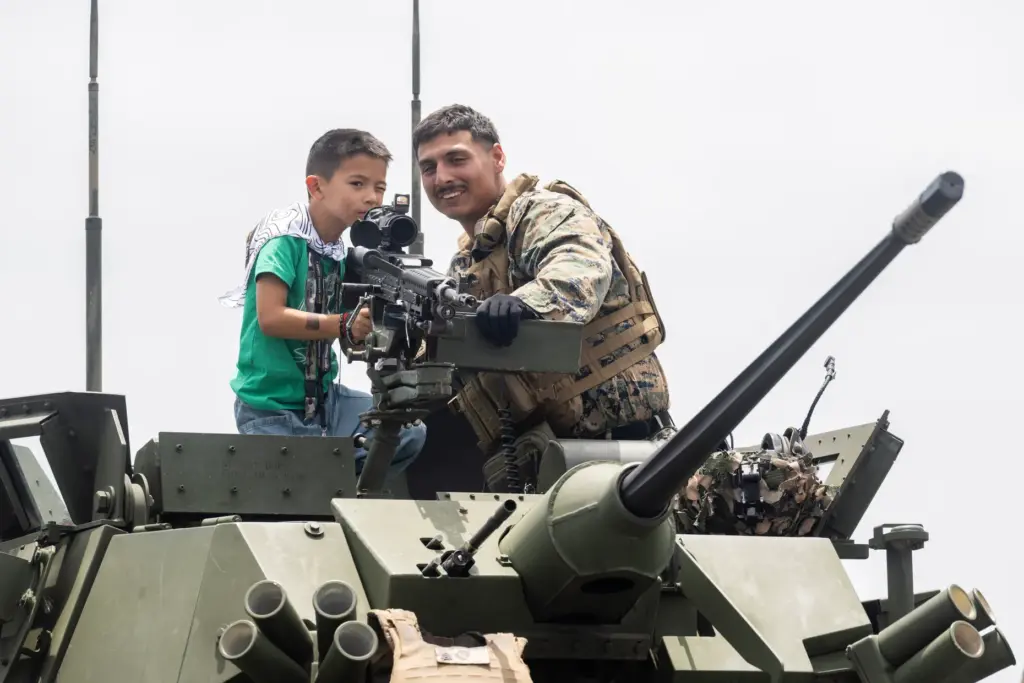 From right, Lance Corporal Joseph Wiwakan teaches six-year-old Mattson Marsteller...