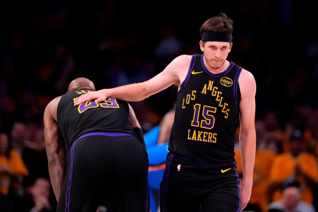 Lakers guard Austin Reaves, right, pats the back of forward...