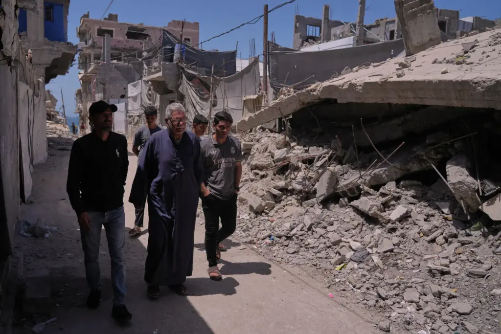 Yusuf Abu walks with his grandchildren and son