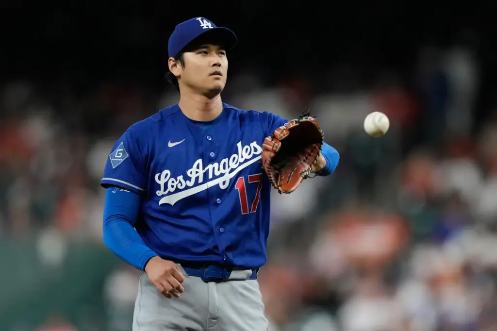 Dodgers starting pitcher Shohei Ohtani catches a new ball from...