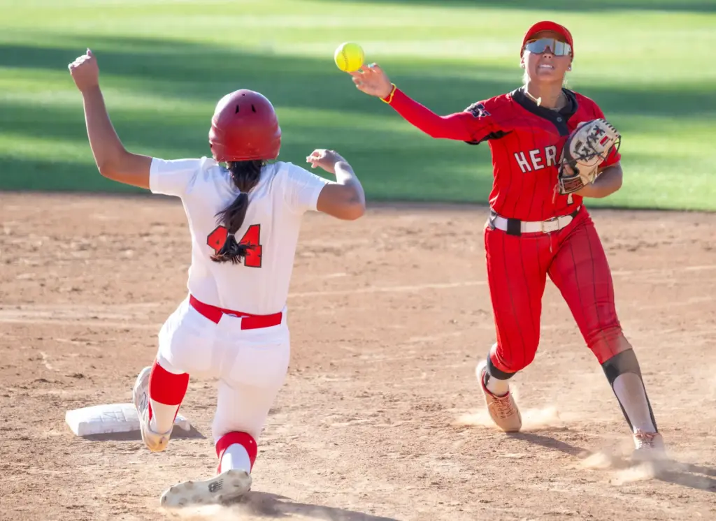Whittier Christian second baseman Gigi Bojorquez throws to first base...
