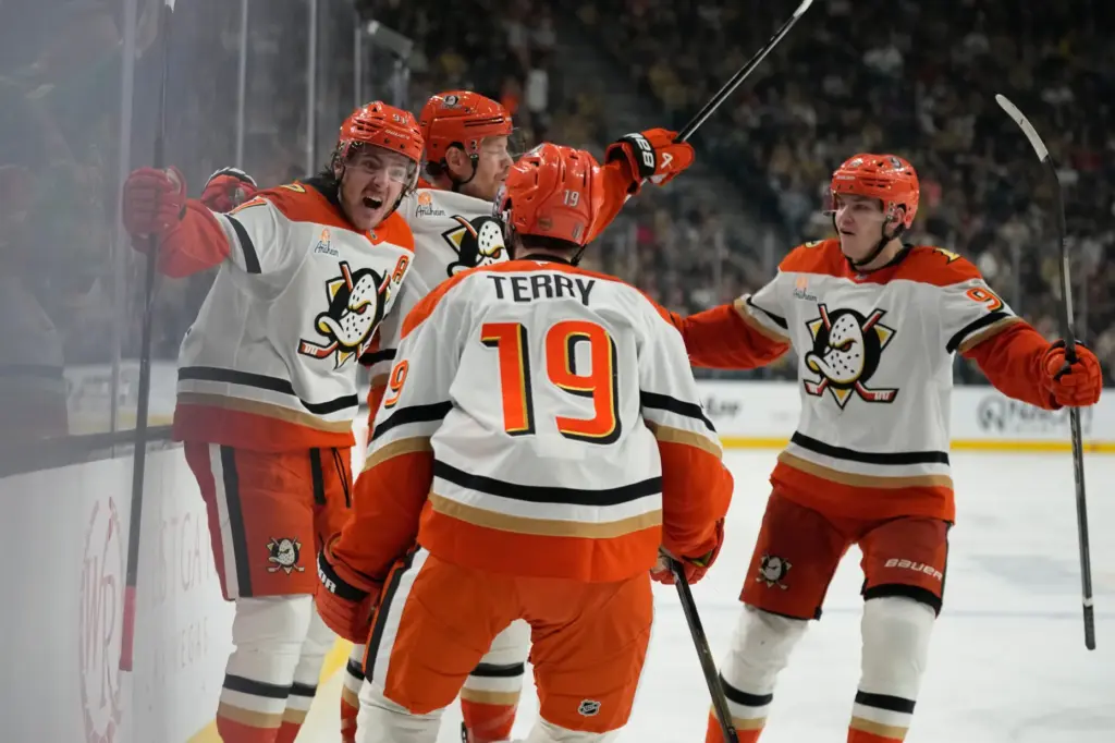 Ducks center Leo Carlsson, left, celebrates after scoring a goal...