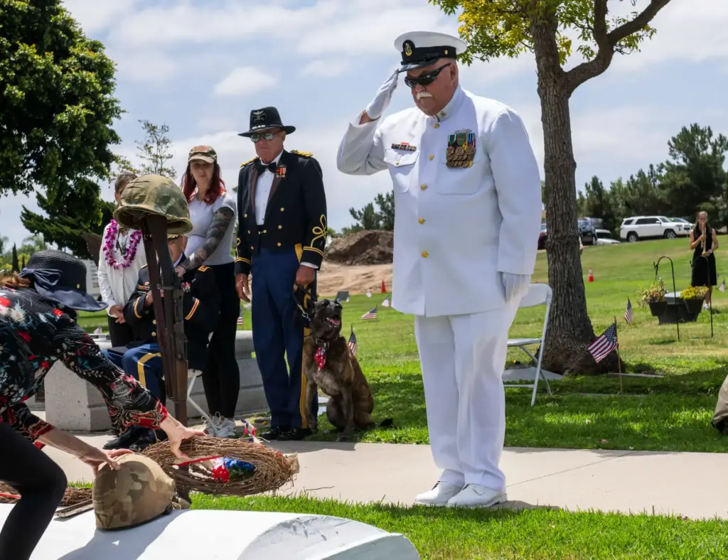 Navy veteran Gary Tegel gives a salute after laying the...