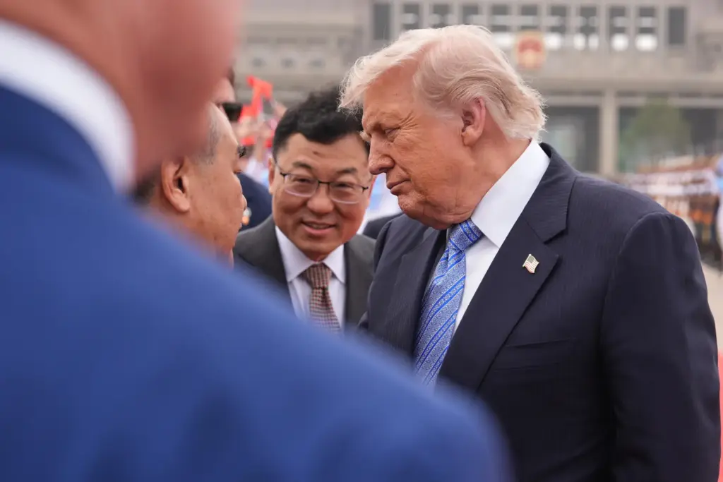 President Donald Trump interacts with China's Foreign Minister Wang Yi.