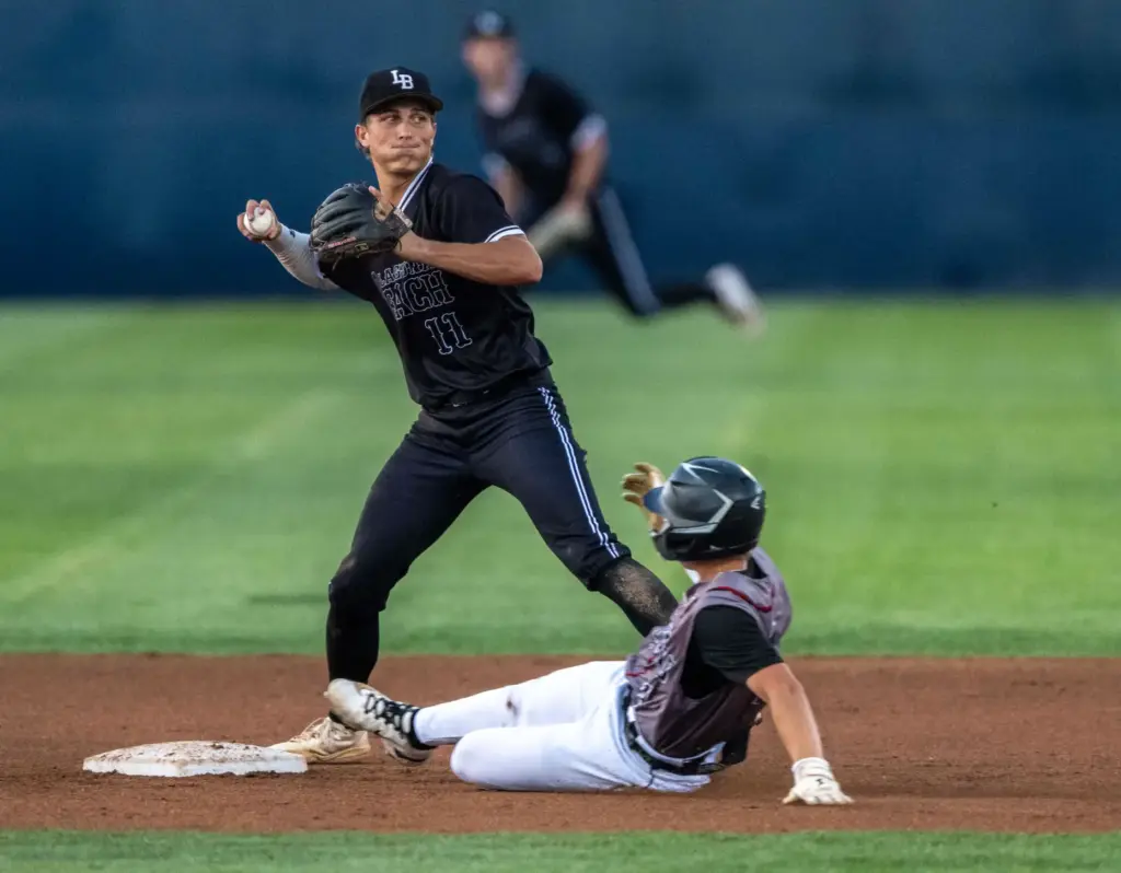Laguna Beach shortstop Lincoln Adams throws to first base after...