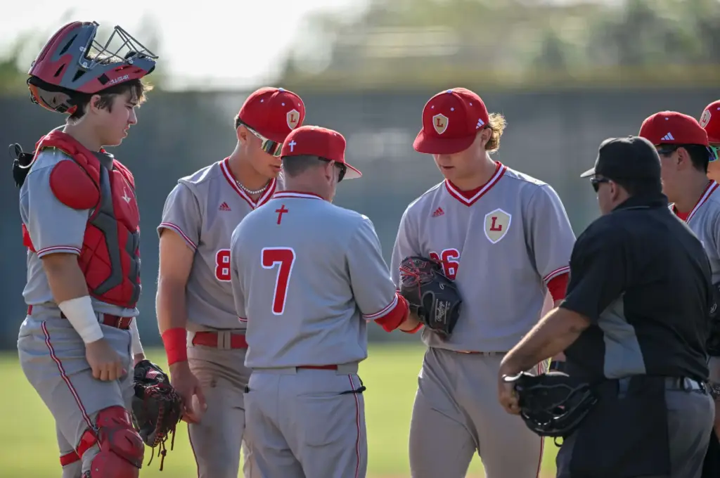 Orange Lutheran coaches, players and the home plate umpire check...