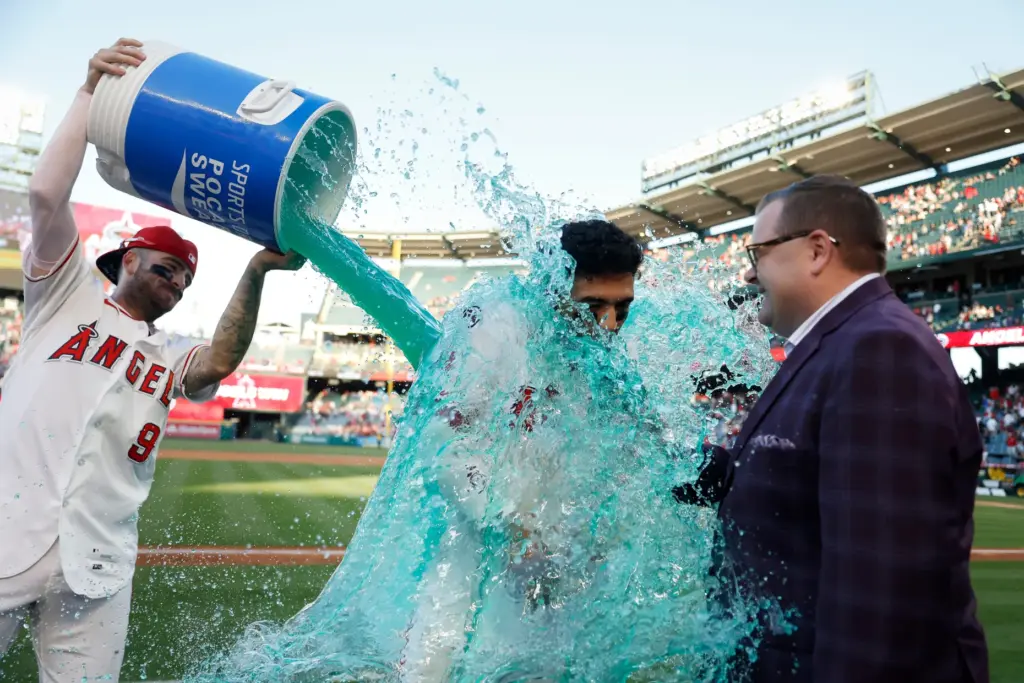 The Angels’ Zach Neto, left, pours a bucket of sports...