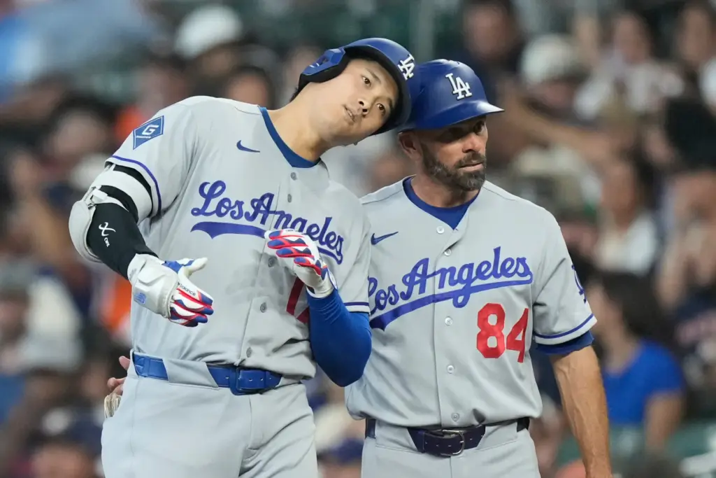 Dodgers star Shohei Ohtani, left, celebrates with first base coach...